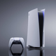 A PlayStation 5 and a controller sitting on a reflective surface in front of a grey background.